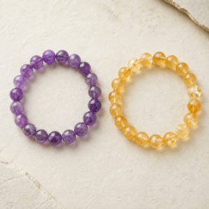 Purple amethyst and golden citrine natural gemstone bracelets arranged for comparison