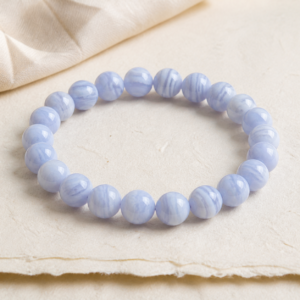 Natural blue lace agate gemstone bracelet with pale blue and white banded beads on ivory paper